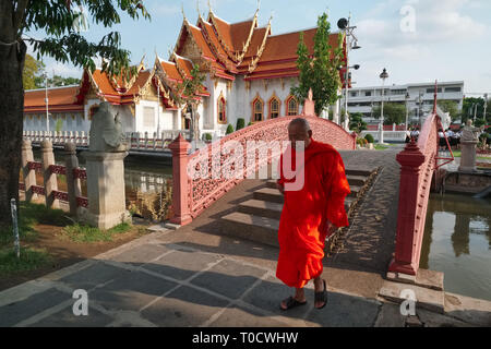Ein buddhistischer Mönch in traditionellen Gewändern Spaziergänge durch die malerische Gelände des Wat Benchamabophit (auch als Marmor Tempel) in Bangkok, Thailand Stockfoto