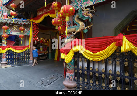 Eine Frau steht im Eingang des Wat Mangkon Kamalawat, einem großen taoistischen Tempel in Chinatown, Bangkok, Thailand, mit chinesischen Laternen dekoriert Stockfoto