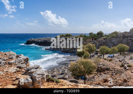 Blick über die Bucht von Marmara Strand mit parasolas auf den Strand und das türkisfarbene Wasser vor einer Taverne in der Nähe des Aradena Schlucht auf der Insel Kreta, Griechenland Stockfoto