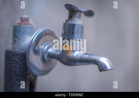 Eine verrostete ohne Wasser vor grauem Hintergrund tippen Stockfoto