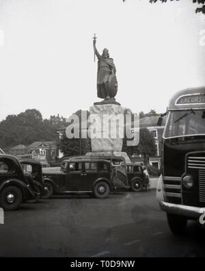 1940, Autos der Epoche um die Statue von Alfred dem Großen, dem sächsischen König, in Winchester, Hampshire, England, UK geparkt. Stockfoto