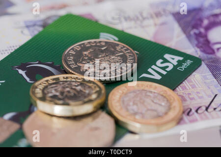Lloyds Visa Debit Card mit einigen englischen Sterling Münzen und Noten. Vereinigtes Königreich Stockfoto