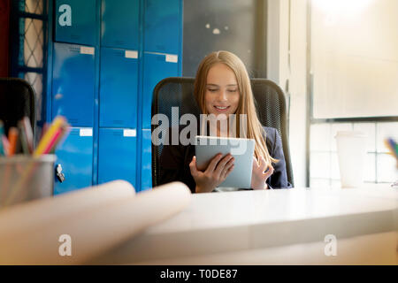 Attraktive junge Frau, die in modernen startup Office Stockfoto