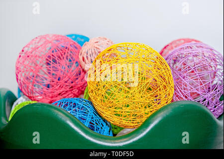 Bunte Kugeln von Threads in eine grüne Vase. Die Inneneinrichtung. Unkonventionelle Verwendung des Materials. Handarbeit. Stockfoto