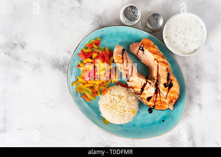 Ansicht von oben Gegrilltes Lachssteak mit gedünsteten Paprika und Reis auf weißem Hintergrund Stockfoto