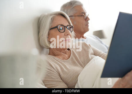 Senior paar Entspannen und Lesen im Bett Stockfoto