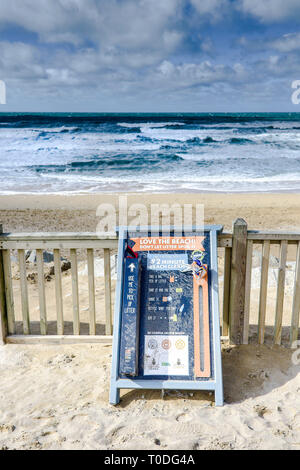 Ein Zeichen Menschen ermutigen, Wurf auf den Fistral Beach in Newquay in Cornwall zu holen. Stockfoto