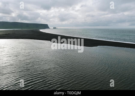 Blick vom Kap Dyrholaey auf Reynisdrangar Basalt sea Stacks. Reynisfjara Strand mit schwarzem Sand vulkanischen Ursprungs, Island Stockfoto