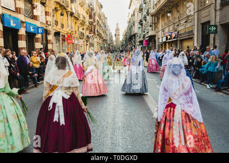 Valencia, Spanien - 17. März 2019: Fallera Kommission paradieren Calle de la Paz, von hinten gesehen, während der Fallas bietet. Stockfoto