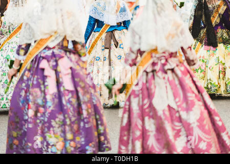 Valencia, Spanien - 17. März 2019: Fallera Kommission paradieren Calle de la Paz, von hinten gesehen, während der Fallas bietet. Stockfoto