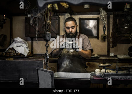 Portrait von bärtigen hipster Küchenchef kneten den Teig für Pizza in der mittelalterliche Markt von Puebla de Sanabria. Zamora Stockfoto