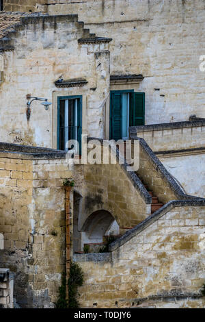 Was aussieht wie lustig traurig Haus Gesicht, auch als pareidolia von Haus mit Treppe, Bogen und zwei Fenster mit Jalousien in Matera, Basilikata, Italien bekannt Stockfoto