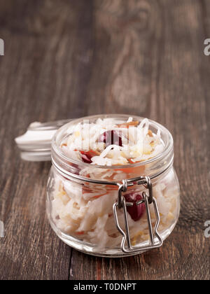 Traditionelle russische Vorspeise Sauerkraut mit Cranberry und Karotten in Glas Glas auf Braun rustikalen Holztisch. Fermentierter Kohl. Russische Küche und russische Küche. Kopieren Sie Platz für Text. Stockfoto