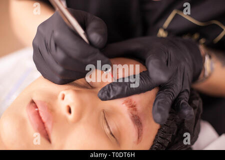 Blick von oben auf die kaukasischen Frau entfernen eine Augenbraue Tattoo in einem Schönheitssalon. Pflege der Haut. Körperpflege. Hygiene Verfahren. Stockfoto