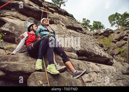 junges Paar in Liebe Kletterer. Mann und Frau auf einem Felsen in den Seilen hängen. Klettern, extreme sport Stockfoto