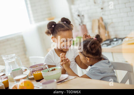 Ziemlich lockig-behaarte Mädchen ihre Hände halten zusammen Stockfoto