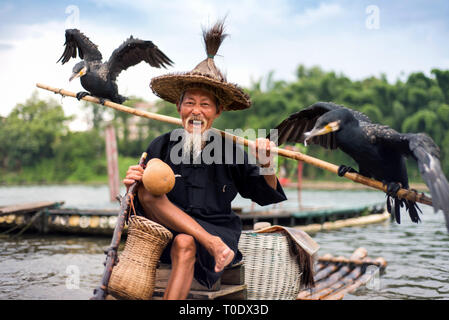 Yangshuo, China - Juli 27, 2018: Traditionelle Kormoran Fischer auf einem bambusflöße auf Li River in der Nähe von Yangshuo Guilin in China Stockfoto