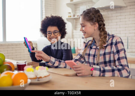 Freundliche internationale junge demonstriert seine neue Telefonnummer Stockfoto