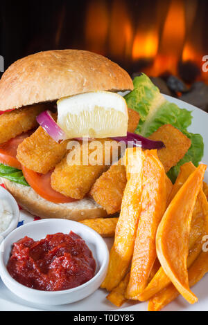 Die typisch englischen Mittagssnack von Fischstäbchen in einem Brötchen, süße Kartoffeln Pommes frites, serviert mit Ketchup und Zahnstein. Stockfoto