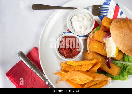 Die typisch englischen Mittagssnack von Fischstäbchen in einem Brötchen, süße Kartoffeln Pommes frites, serviert mit Ketchup und Zahnstein. Stockfoto