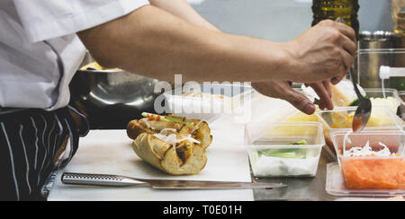 Küchenchef Sandwich in der Küche, leckeres Sandwich mit Gemüse und Fleisch Stockfoto