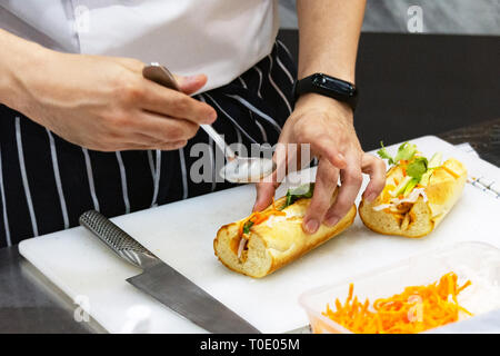 Küchenchef Sandwich in der Küche, leckeres Sandwich mit Gemüse und Fleisch Stockfoto