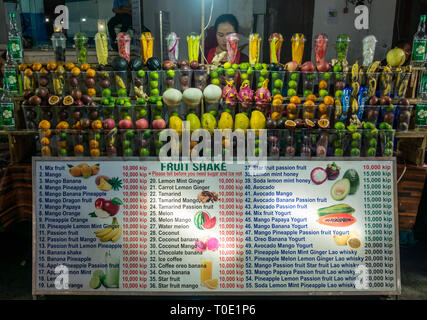 Frau Inhaber bei Obst schütteln Getränke Abschaltdruck am Street Food Night Market Stall, Luang Prabang, Laos, Se Asien Stockfoto