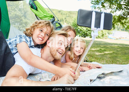 Familie mit zwei Kindern im Zelt ist ein selfie mit Smartphone auf selfie Stick Stockfoto