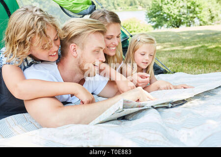 Familie mit zwei Kindern im Zelt betrachten eine Karte auf camping urlaub Stockfoto