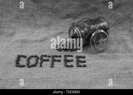 Kaffee Bohnen, Kaffee und ein antikes Glas mit Bohnen, verschüttet Stockfoto