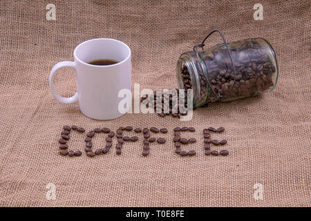 Kaffee Bohnen, Kaffee, Kaffeetasse, und ein Glas mit Bohnen, verschüttet Stockfoto