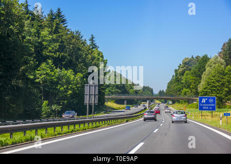 Deutschland. Tag Sommer. Auto Verkehr auf einer Vorstadt Landstraße Stockfoto