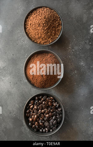 Konzept der verschiedenen Phasen Kaffeebohnen in Schalen auf dunklem Hintergrund. Ansicht von oben. Stockfoto