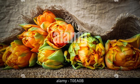 Schöne orange Tulpen mit einem leinen Servietten Stockfoto