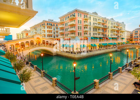 Luftaufnahme von zwei Venezianischen Brücken über die Kanäle der malerischen und luxuriösen Viertel von Doha leuchtet an der blauen Stunde. Malerische Venedig bei Qanat Quartier Stockfoto