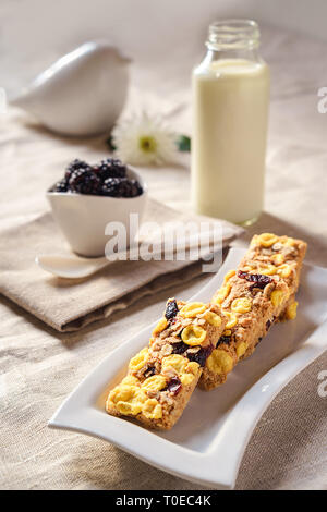 Leckere Diät kalorienarme Plätzchen mit Beeren, Flasche Milch und Brombeeren auf natürliche Farbe Tischdecke und Home Dekoration auf hellgrauem Hintergrund. lifestyle Konzept. Stockfoto