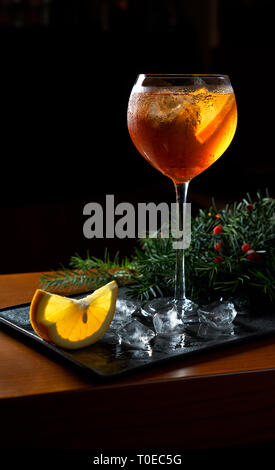Aperol Spritz Cocktail mit Orangenscheiben und Eis auf schwarz Fach auf dunklen für Feier Stockfoto
