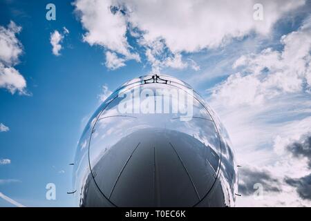 Reflexion von Wolken am Flugzeug. Nahaufnahme von Cockpit gegen den Himmel. Stockfoto