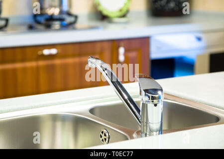 Schuss für die saubere Chrom Wasserhahn und Waschbecken in der Küche hautnah Stockfoto