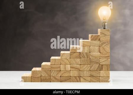 Konzept der Idee und Innovation, Glühbirne leuchtet oben auf einer Treppe. Stockfoto