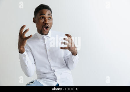 Wow. Attraktive männliche Hälfte - Länge vorne Portrait auf Grau studio Hintergrund. Jungen afro emotionale überrascht, bärtigen Mann mit offenen Mund. Menschliche Gefühle, Mimik Konzept. Stockfoto