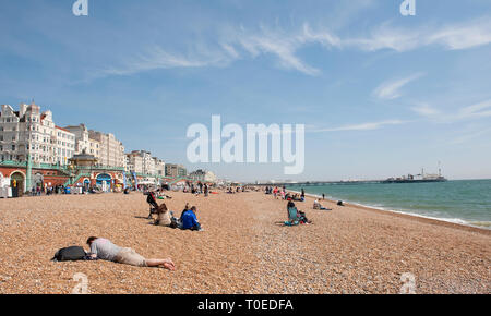 Menschen entspannen am Strand an einem sonnigen Tag in Brighton, Sussex, England. Stockfoto