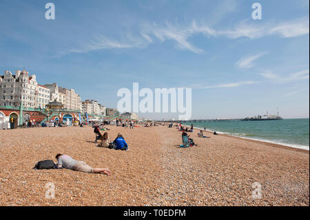 Menschen entspannen am Strand an einem sonnigen Tag in Brighton, Sussex, England. Stockfoto