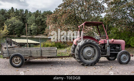 Retro red old Traktor mit Wagen Stockfoto