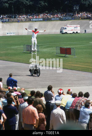 1974, Tricks Motorradfahrer stehen auf einer Leiter Motorrad fahren unterhalten die Zuschauer am Ende der Tour de France Radrennen auf den Track am Velodrom de Vincennes, Paris, Frankreich. Dies war im letzten Jahr die Tour beendet am velodrom wie im folgenden Jahr zu den Champs-Elysees verschoben. Stockfoto