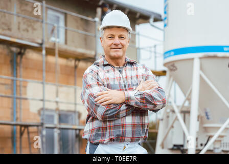 Stolz Gipser stand vor der Gerüst auf der Baustelle Stockfoto