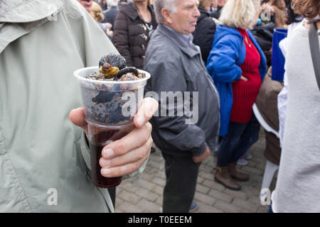 Eines erwachsenen Hand mit einem Plastikbecher voll der heiße frisch gerösteten Kastanien carbonhydrates bei der jährlichen Kastanien rösten Festival der Leivadi, Griechenland. Stockfoto