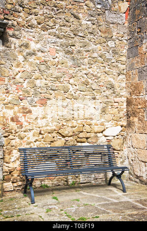 Leere Bank an Steinwand Stockfoto