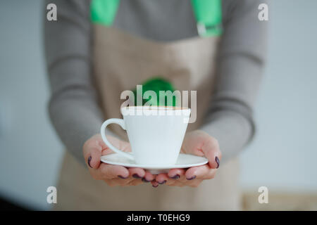 Barista in Schürze im Coffee Shop nur gebraut frischen Kaffee an Kunden geben. Stockfoto