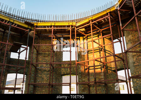 Baustelle. Der Rahmen und die Wände des Hauses sind aus Ziegelsteinen gemauert. Aufbau von Panels in einem Haus im Bau Stockfoto